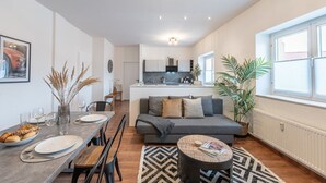 Eine moderne Wohnung mit Essbereich, Wohnzimmer und Küche.