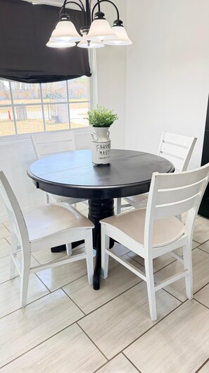 A round dining table with a white pitcher labeled "FARMER MARKET" and a small plant on it. -  Welcome to Casa Alafia at Riverview. (Riverview)