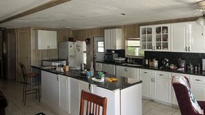 A kitchen with white cabinets, a central island, and a window.