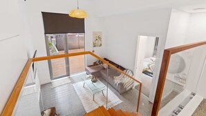 A modern interior with a staircase, a glass table, and a sofa. - 2BR Loft |A/C, Netflix, Private Deck| Walk to City (Auckland Central)