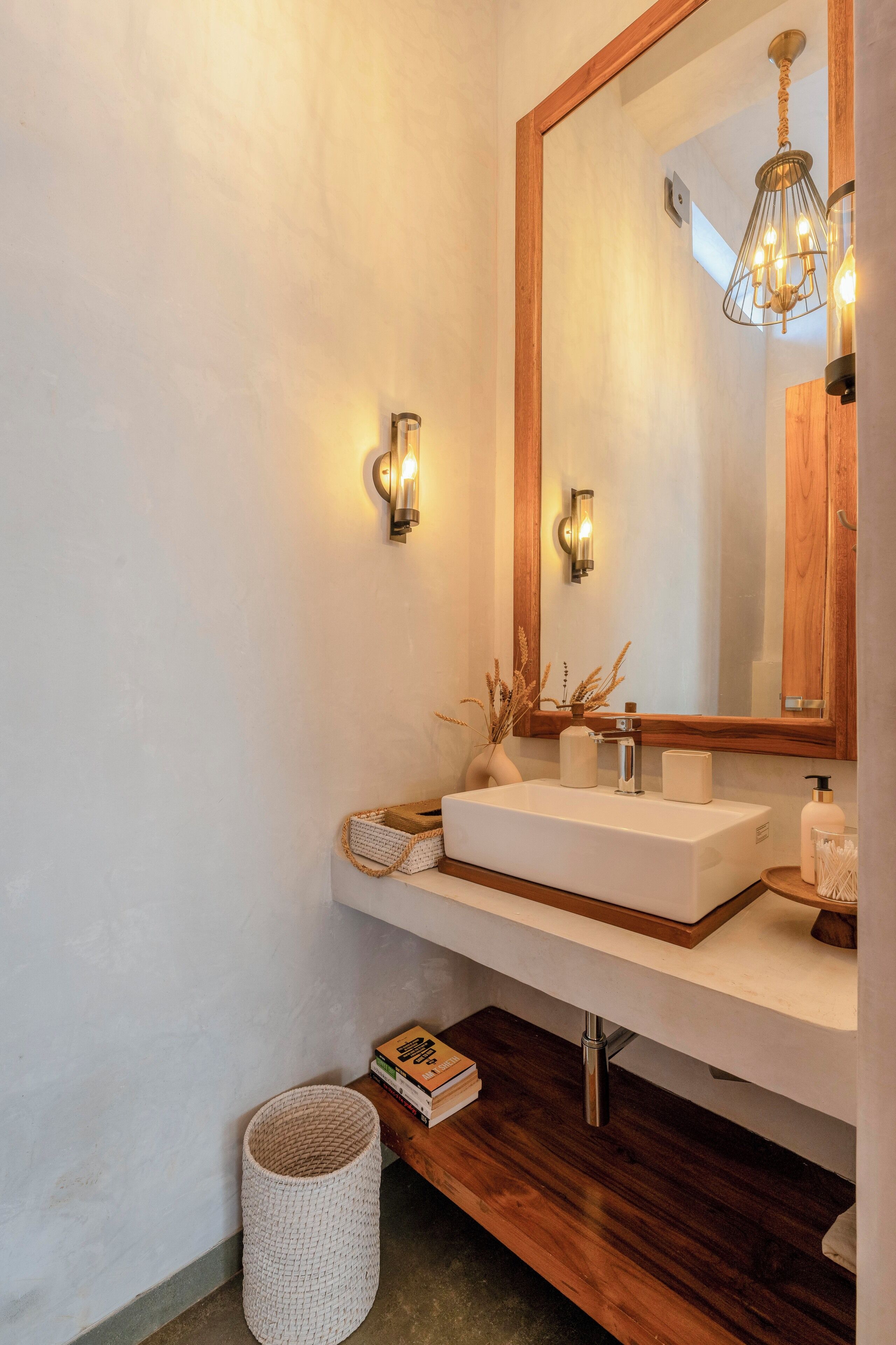 A modern bathroom with a large mirror, white sink, and wooden vanity.