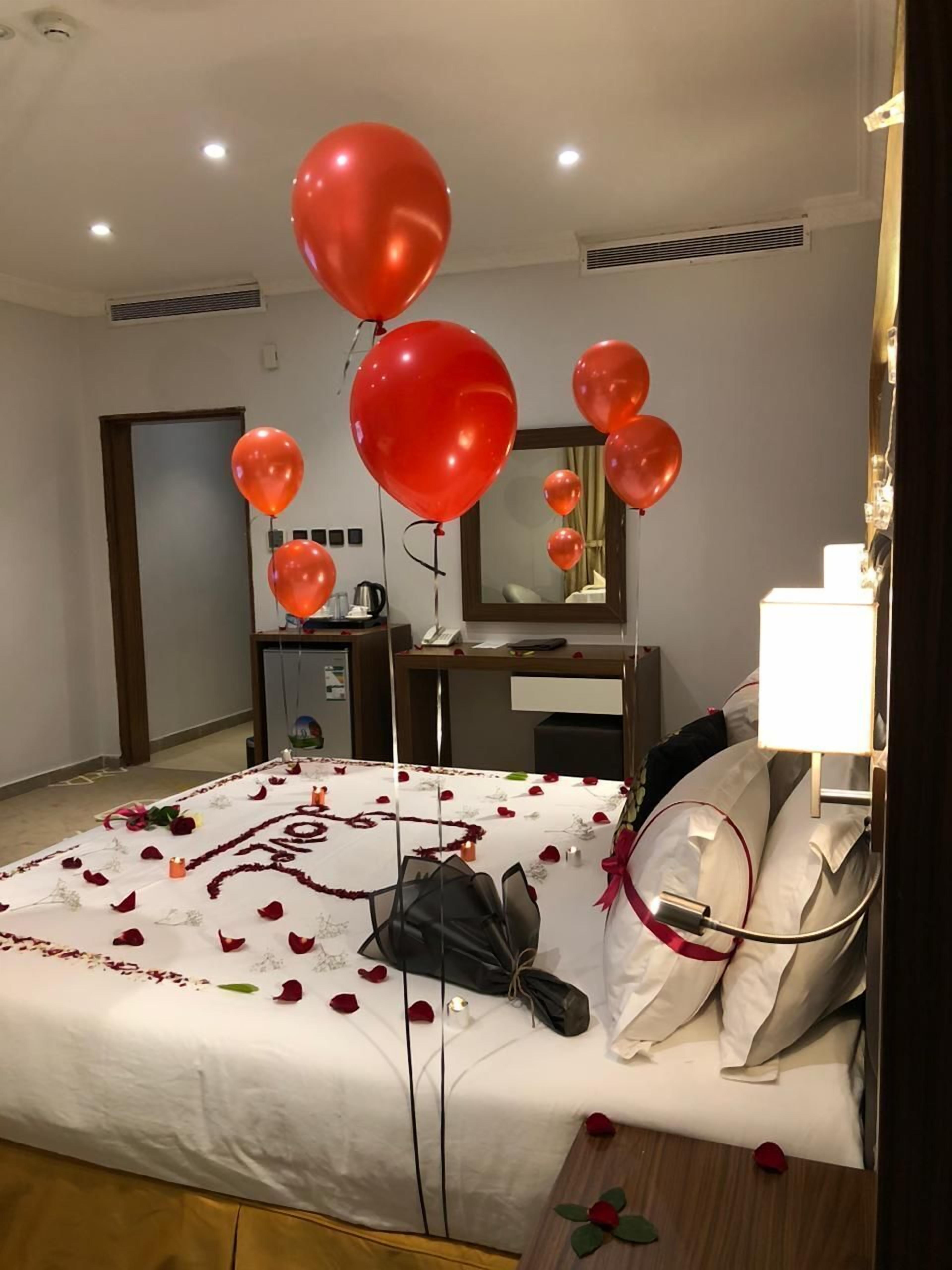 A hotel room with a bed, a desk, and a mirror.