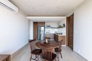 Eine moderne Küche mit weißen Schränken, einem Edelstahl-Kühlschrank und einer Mikrowelle.