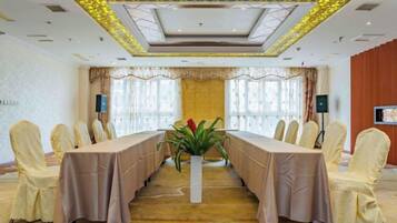 A conference room with a long table, chairs, and a plant.