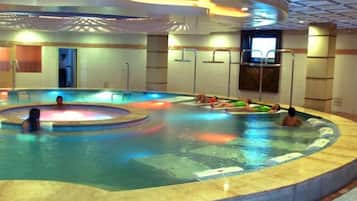 Una piscina interior con varias pistas de natación y una zona central de relajación.