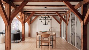 A dining area with wooden beams, a chandelier, and a table with chairs. - Nyhavn43 Suites 4 by Daniel&Jacob´s (København)