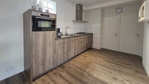 Eine moderne Küche mit Einbauofen, Dunstabzugshaube und Spüle.