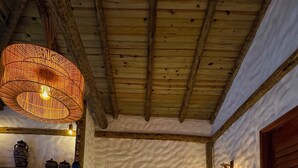 A bed with a white quilt, a woven light fixture above, and a rustic wooden ceiling. - Vila Calm Bungalows - Serra da Ibiapaba - Views of the mountains and the city. (Várzea do Giló)