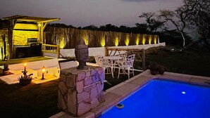 A pool area with a stone wall, outdoor seating, and a covered structure. - Vila Calm Bungalows - Serra da Ibiapaba - Views of the mountains and the city. (Várzea do Giló)