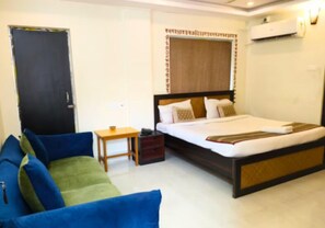A bedroom with a bed, a desk, a chair, and a wardrobe. - The Kolam (Bolpur)