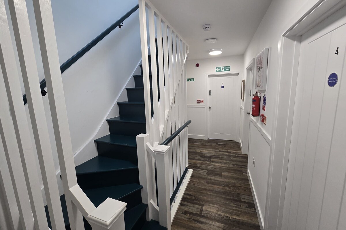 A staircase with white railings and dark steps leading to a door marked with the number 4.