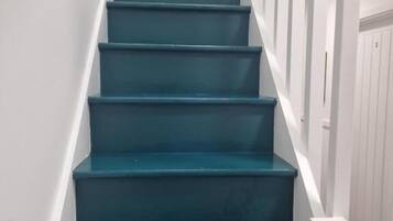 A staircase with teal steps and white railings.