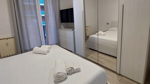 Una camera d'albergo con un letto, uno specchio e un armadio.