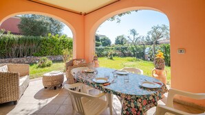 A covered patio with a table set for dining, wicker furniture, and a view of a garden. - Cottage with Garden in the Center – Private Terrace, Private Garden, Air Conditioning (Suaredda-traversa)
