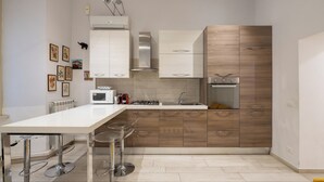 Eine moderne Küche mit weißer Arbeitsplatte, Edelstahlgeräten und Holzschränken.