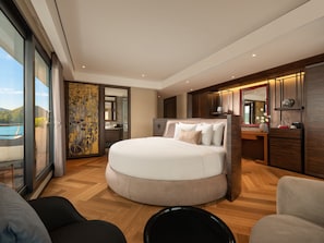 A modern hotel room with a large bed, a sitting area, and a view of the outdoors. - La SEN of the Bay Cruises  (Tuan Chau)