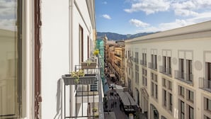 Eine enge Straße mit Häusern an beiden Seiten, ein klarer Himmel und Berge in der Ferne.