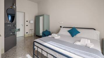 Ein Hotelzimmer mit Bett, Schrank, Spiegel, Waschbecken und Lampe.