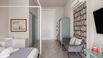 A bedroom with a bed, a desk, a bookshelf, and a door leading to another room.