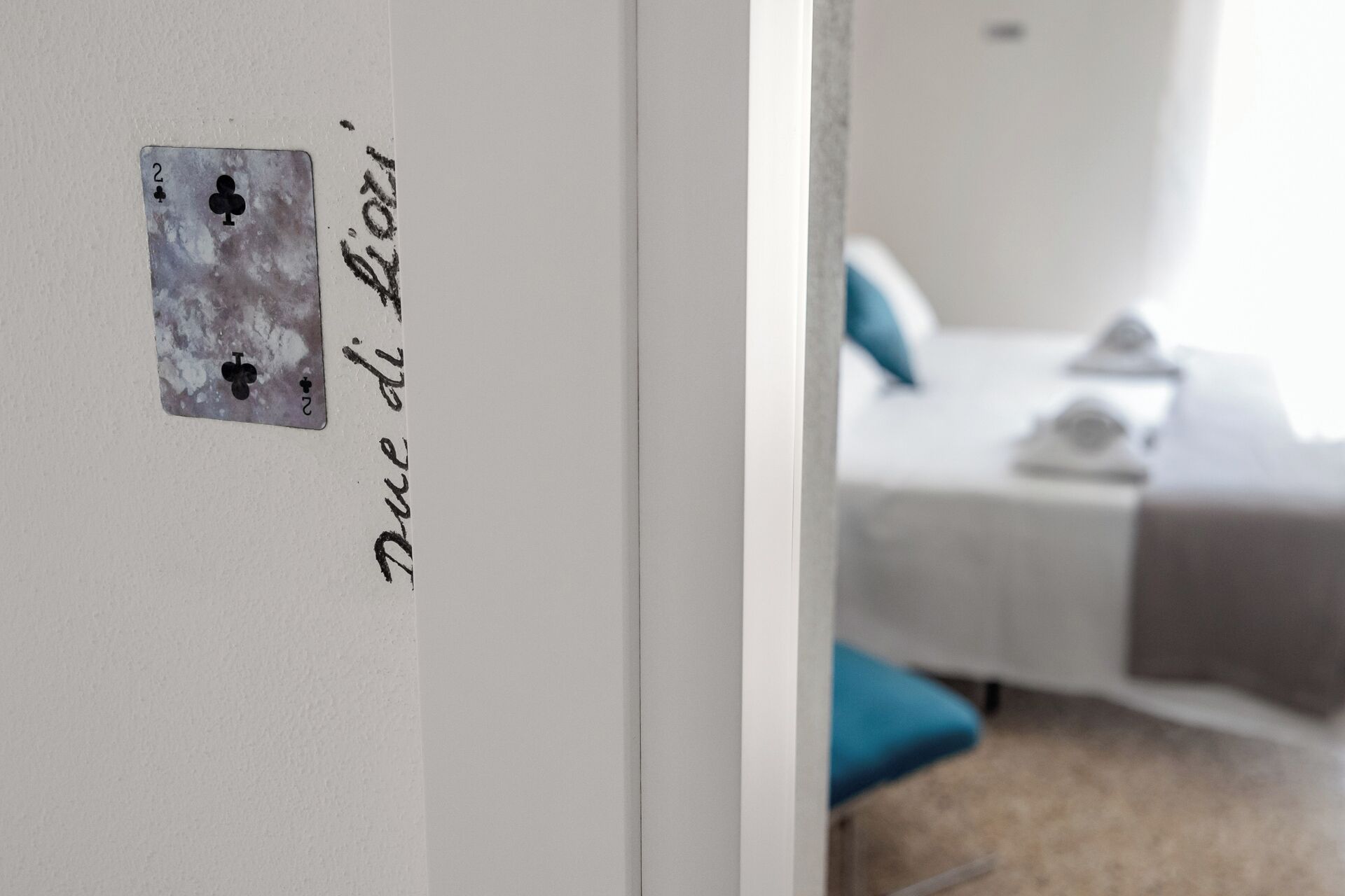 A room with a bed, a bedside table, and a wall with a door.