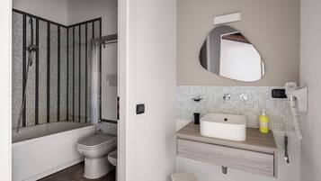 Ein Badezimmer mit Dusche, Toilette, Waschbecken und Spiegel.