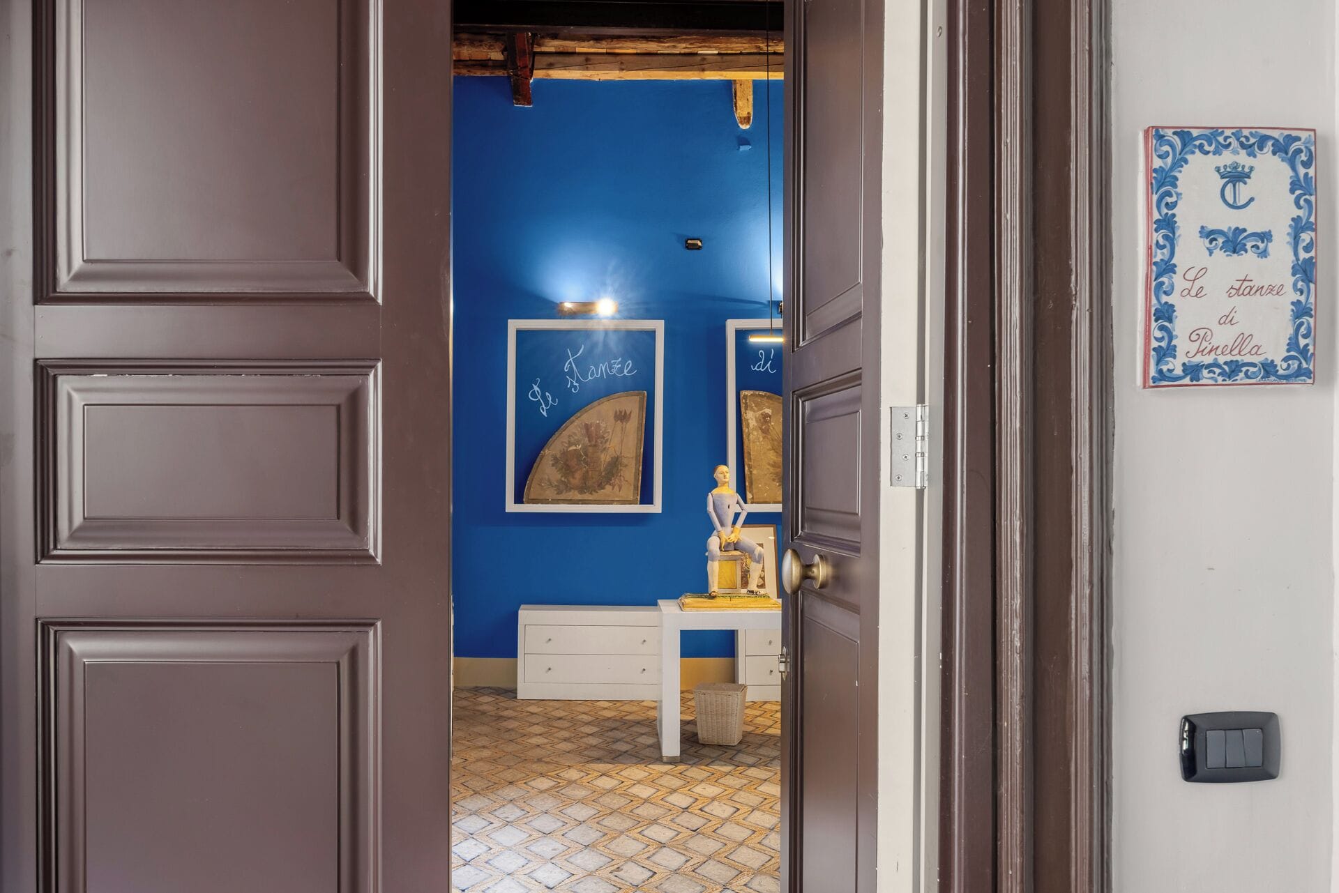 Ein Innenraum mit blauer Wand, weißem Schreibtisch und einem gerahmten Bild.