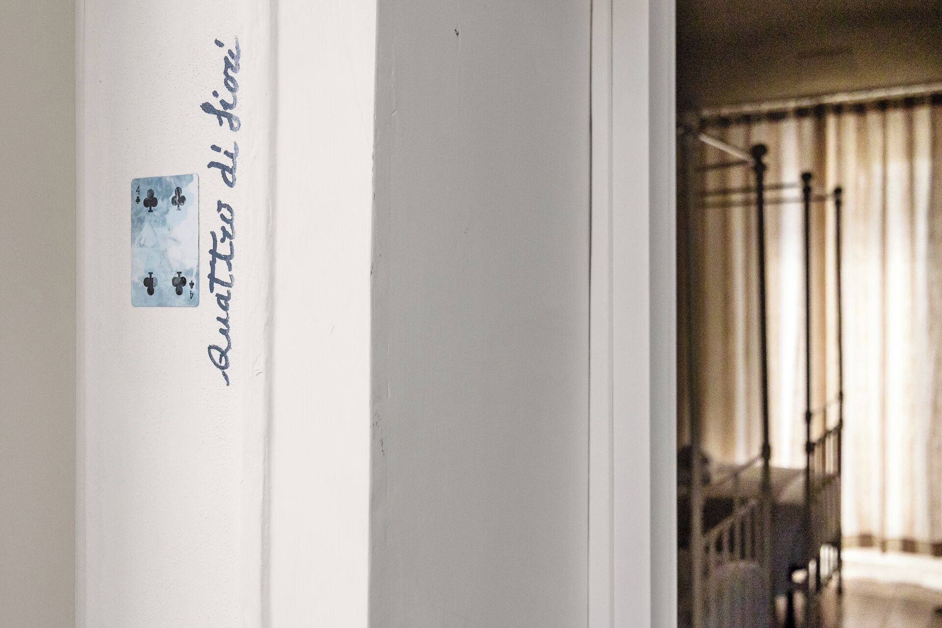 Una puerta con un cartel escrito a mano y una vista parcial de una habitación con una escalera.