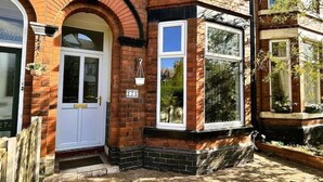 A brick house with a white front door, a bay window, and a number plaque. - Salisbury Place by SG Property Group (Crewe)