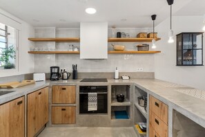 A modern kitchen with wooden cabinets, a built-in oven, and a coffee maker.