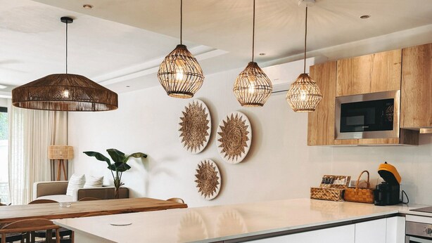 A modern kitchen with a central island, pendant lights, and decorative wall art.