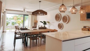 A modern kitchen with a dining area, large windows, and decorative wall art.