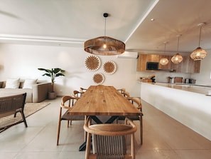 A modern kitchen with wooden cabinets, a central island, and pendant lighting.
