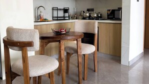 Eine moderne Küche mit weißen Schränken, einem Holztisch und Stühlen.