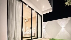 A modern bedroom with a sliding glass door, a bed, and a nightstand. - La Vizta Weligama (Weligama)