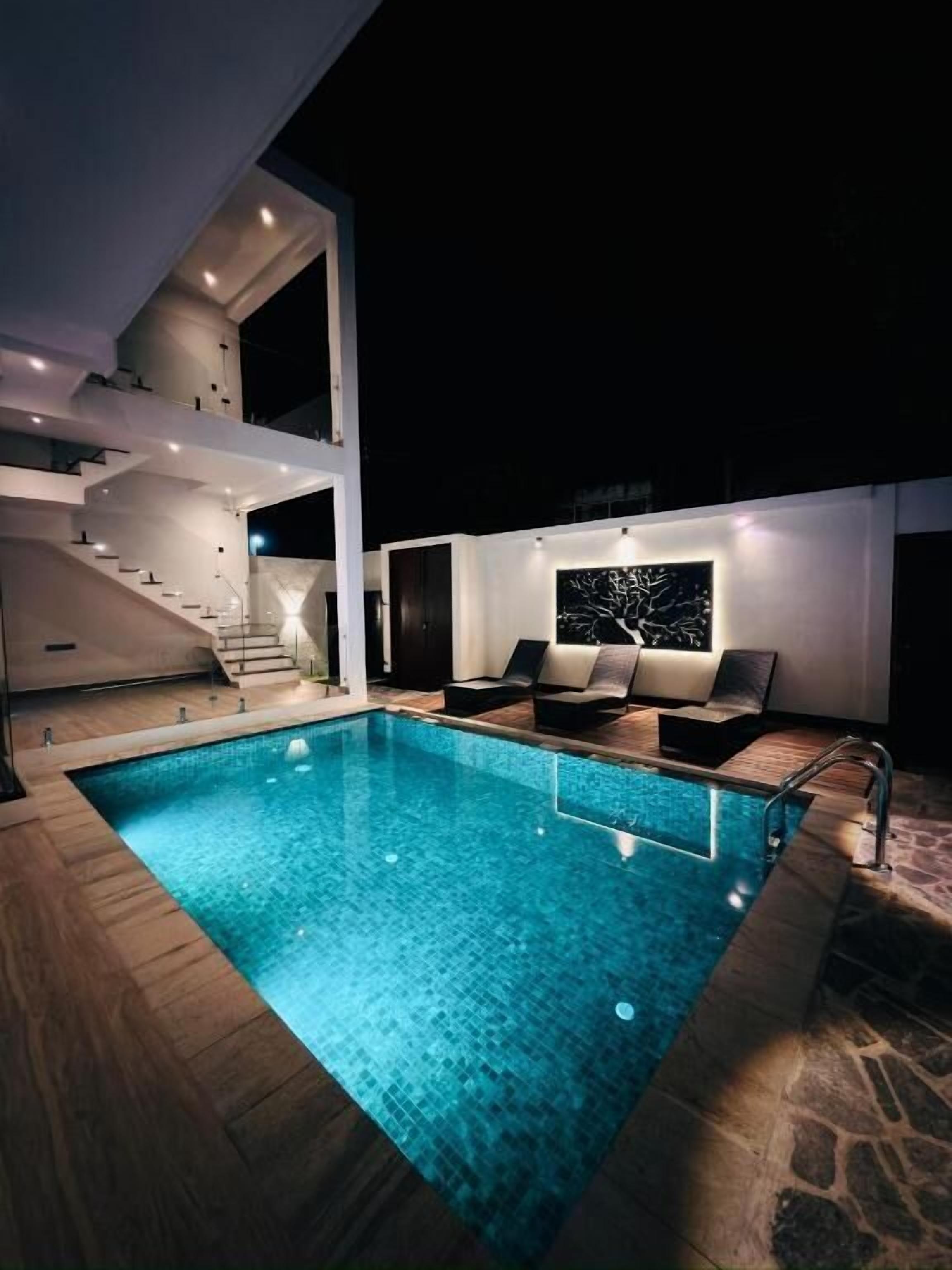 Una piscina al aire libre, sillones reclinables de piscina