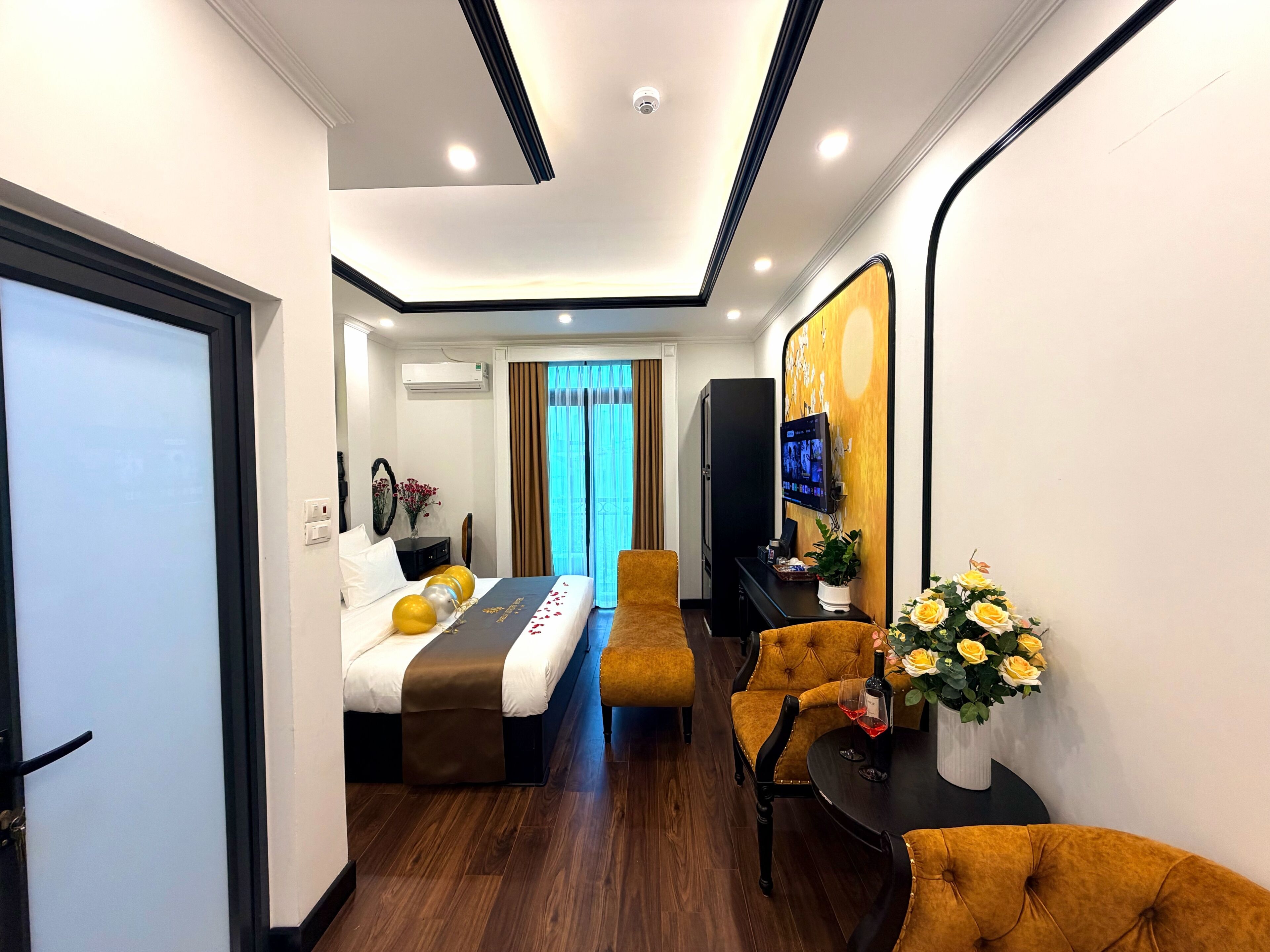 Een hotelkamer met een bed, een bank, een televisie en een tv aan de muur.