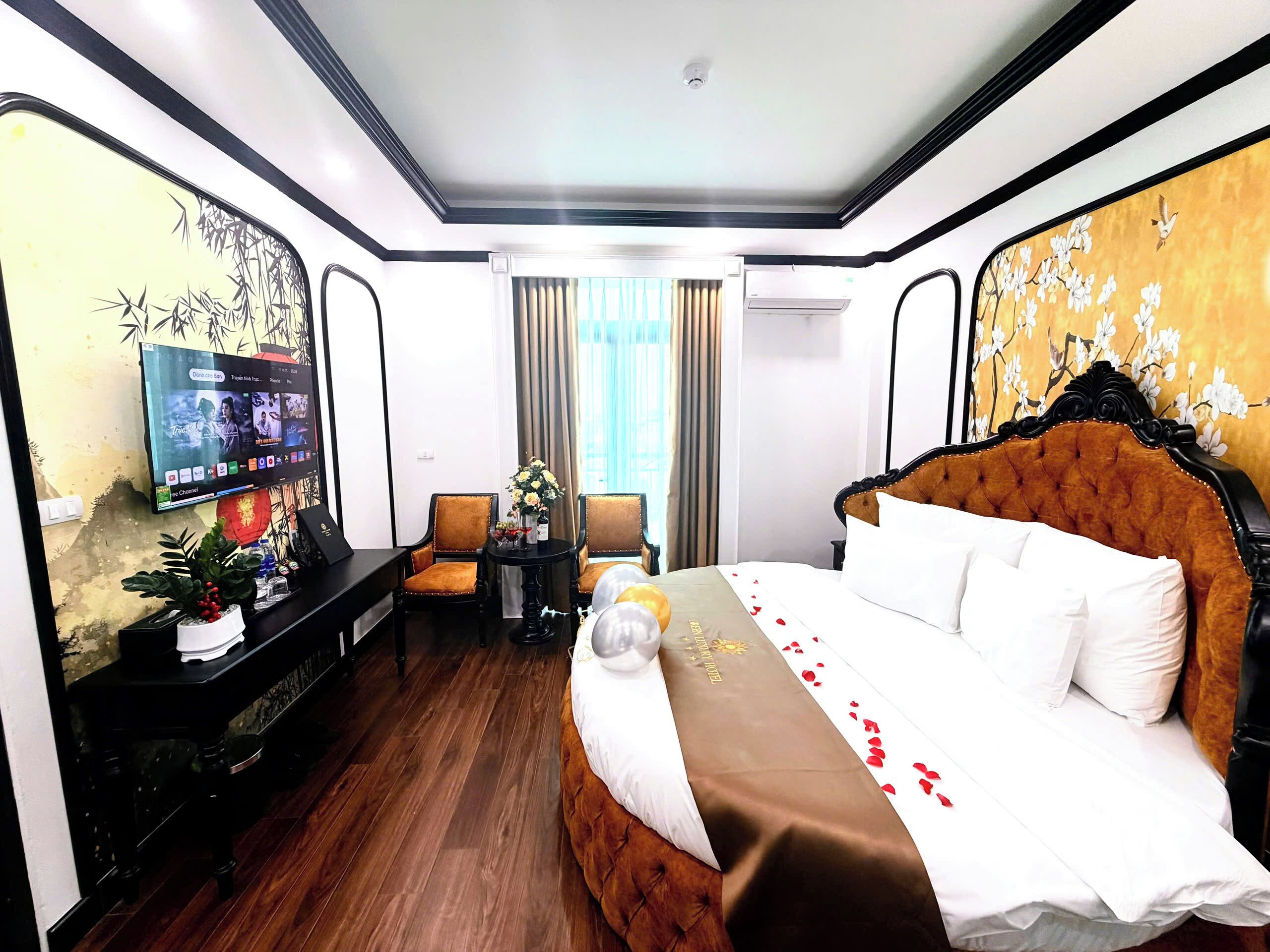 A hotel room with a bed, a TV, a desk, and a chair.