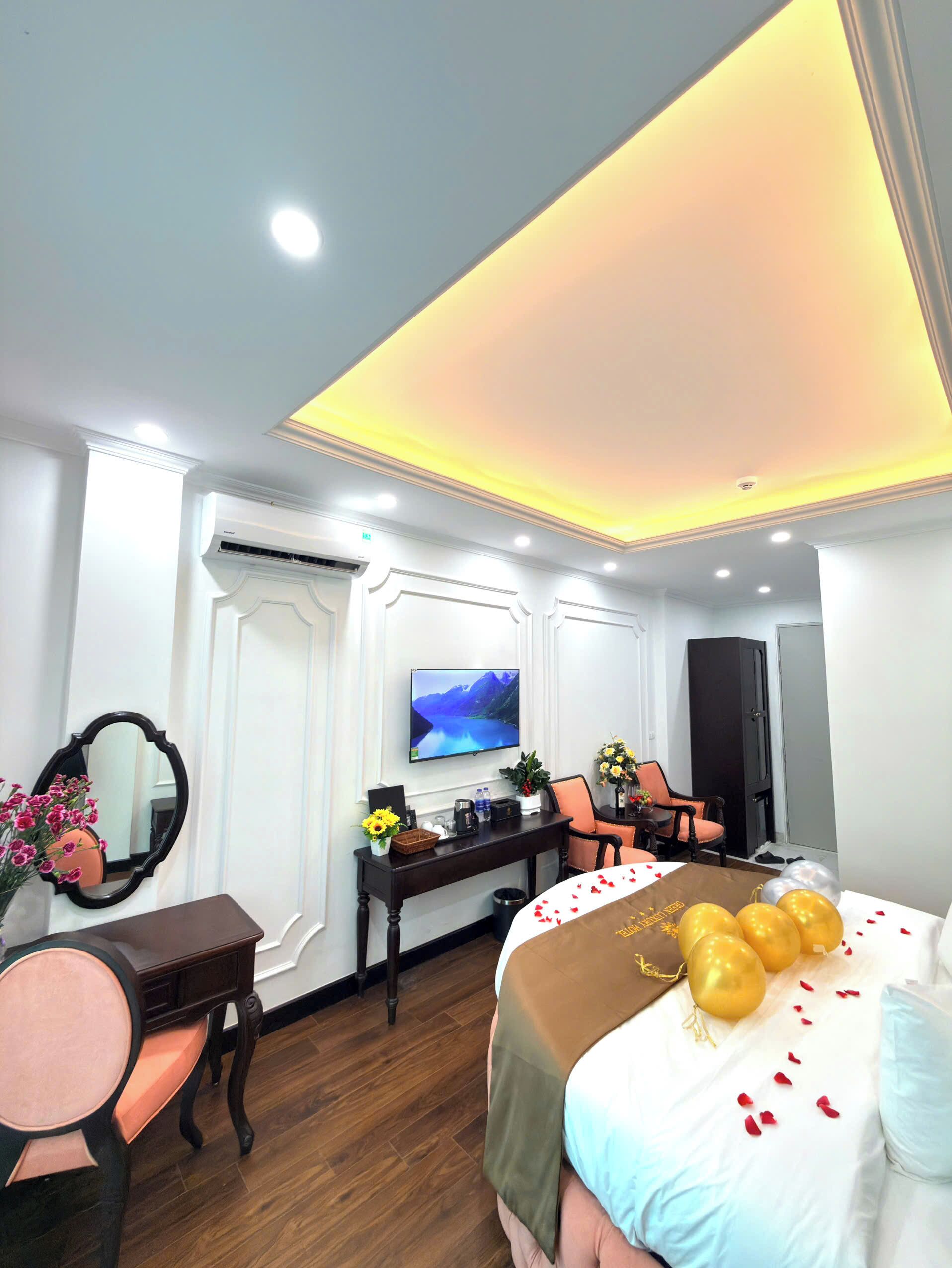 Une chambre d’hôtel avec un lit, un bureau, une télévision et un miroir.