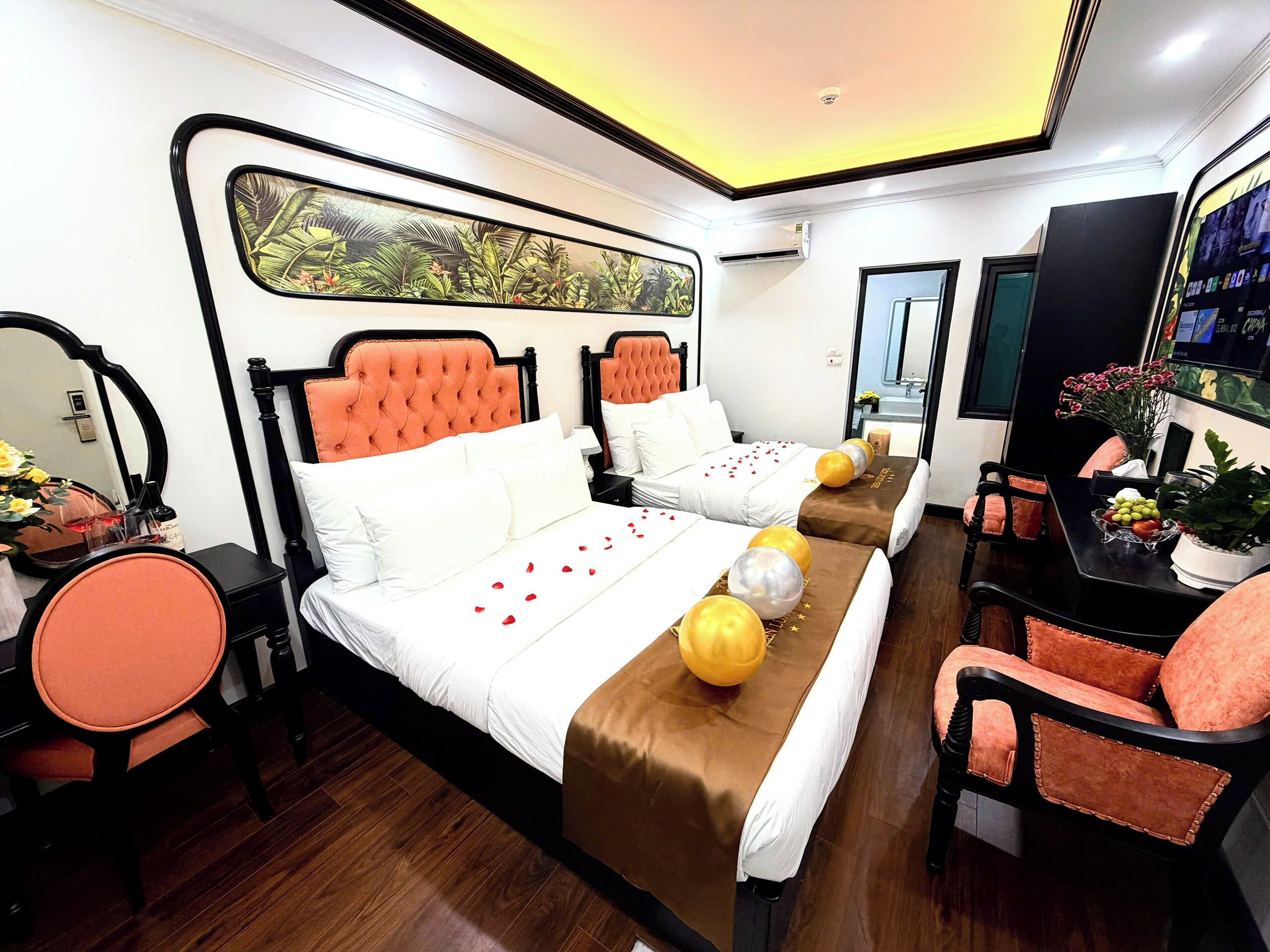 A hotel room with two beds, a TV, a desk, and a chair.