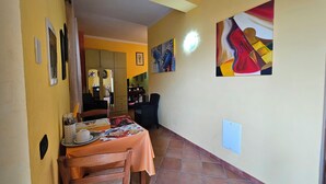 A dining area with a table set for two, chairs, and a tiled floor.