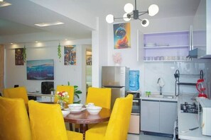 A modern kitchen with a dining area featuring yellow chairs and a round table. - Peaceful 3-Bedroom Oasis at Orchid Residency – Westlands, Nairobi (Nairobi)
