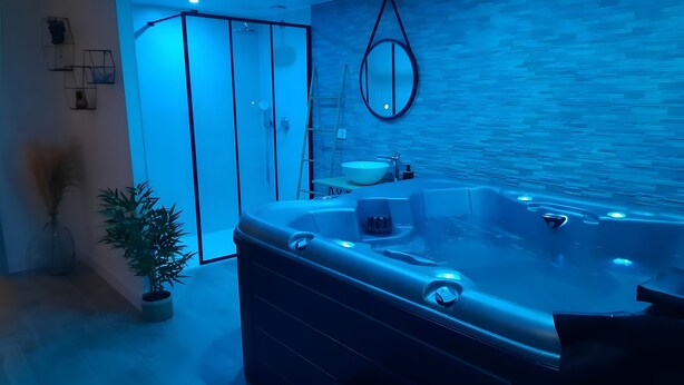 A modern bathroom with a large bathtub, a shower area, and a sink.