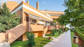 A modern building with a flat roof, a covered walkway, and a well-maintained lawn. - Ca di Valle Retreats (Cavallino-Treporti)