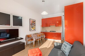 A compact living space with a dining area, kitchenette, and a TV. - Ca di Valle Retreats (Cavallino-Treporti)