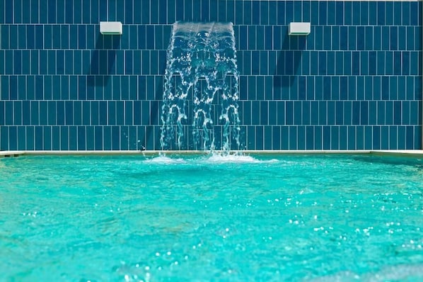 Une piscine avec une fontaine au centre.