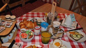 A breakfast table with croissants, eggs, toast, and various condiments. - Pension Leopoldine (Hallstatt)