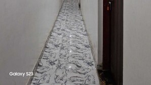 A narrow hallway with a marble floor and a door on the right. - Shri Krishna Niwas (Mathura)