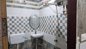 A bathroom with a toilet, sink, and shower. - Shri Krishna Niwas (Mathura)