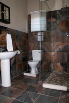 Casa de banho com lavatório, sanita e zona de duche.