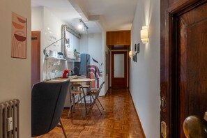 A kitchen with a dining area, wooden flooring, and a door with a handle. - GuestHost - Cozy 90m2 apartment, perfect for 4 people, located on the ground floor of a typical building with cloister.The accommodation is located in the Re di Roma/San Giovanni district, a lively and central residential and commercial area.The city's (Rome)